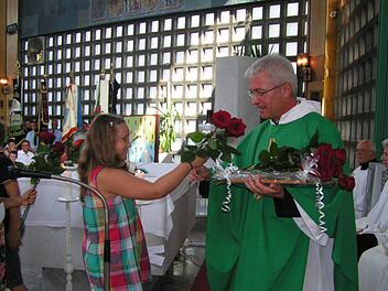 Ein diesjähriges Kommunionkind überreicht eine Rose an Pfarrer Gerhard Möckel.  Foto: Heidi Amon