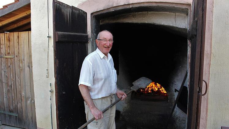 Das Feuer brennt bereits: Geo Paulus, Bäckermeister aus Sambach, bäckt im alten Holzbackofen jede Woche Brot.  Foto: Evi Seeger