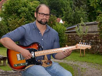 Sebstian Voll ist Hobbymusiker, hat sich das Gitarre spielen selbst beigebracht. Mittlerweile komponiert der Gefäller auch Lieder und singt sie im Rhöner Dialekt. An diesem Sonntag gibt er sein Debüt auf einem Festival in Mittelfranken. Foto: Kathrin Kupka-Hahn