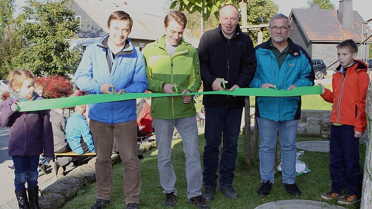 Symbolisch durchtrennten in Ortsteil Dörnach (v.l.) Bürgermeister Jens Korn, Projektmanager Björn Stumpf, Obmann Jürgen Schlee und Wegewart Ludwig Wunder das grüne Frankenwaldband.  Foto: Michael Wunder