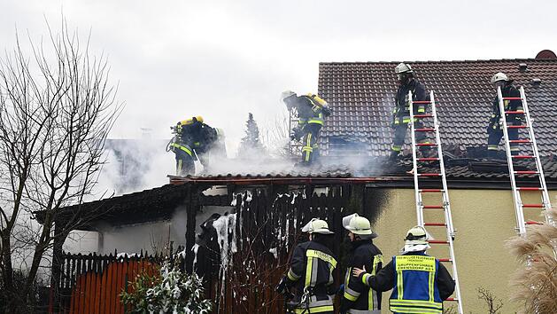 Die Holzlege (links) brannte komplett aus. Die Einsatzkr&auml;fte mussten au&szlig;erdem einen Teil des Wohnhausdaches abdecken. Foto: Ronald Rinklef