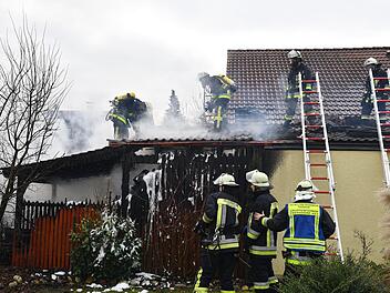 Die Holzlege (links) brannte komplett aus. Die Einsatzkräfte mussten außerdem einen Teil des Wohnhausdaches abdecken. Foto: Ronald Rinklef