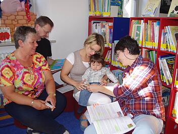 Jan Levi betrachtet auf dem Schoss seiner Mutter Kathrin Günther ein Bilderbuch. Mit im Bild sind (von links) Maria Pestke, Achim Günther sowie Sabine Wank. Das Bild stammt vom ersten Treffen der "Kronacher Büchergeister" im Büchertreff am Melchior-Otto-Platz in Kronach.Foto: Heike Schülein