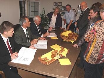 Bürgermeister Johann Pfister, Josef und Matthias Kröner (sitzend, von rechts) signieren das Jubiläumsbuch.  Fotos: Peter Fischer