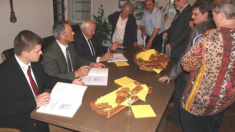Bürgermeister Johann Pfister, Josef und Matthias Kröner (sitzend, von rechts) signieren das Jubiläumsbuch.  Fotos: Peter Fischer