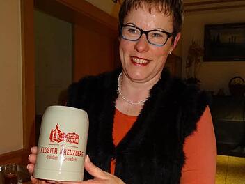 Auch auf dem neuen Bierkrug, den Geschäftsführerin Angelika Somaruga präsentierte, ist das neue Logo des Kreuzbergs zu sehen. Unter der Silhouette des Klosters und den drei Kreuzen ist der Schriftzug "Kloster Kreuzberg - glauben und genießen" zu lesen. Foto: Thomas Pfeuffer