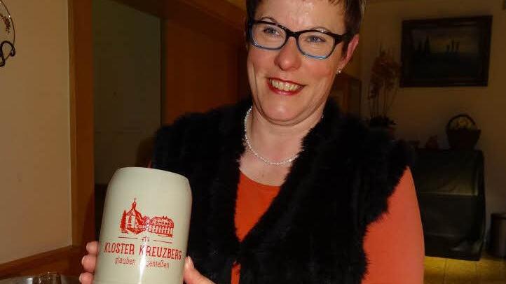 Auch auf dem neuen Bierkrug, den Geschäftsführerin Angelika Somaruga präsentierte, ist das neue Logo des Kreuzbergs zu sehen. Unter der Silhouette des Klosters und den drei Kreuzen ist der Schriftzug "Kloster Kreuzberg - glauben und genießen" zu lesen. Foto: Thomas Pfeuffer