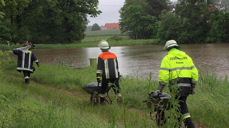 Die Feuerwehrm&auml;nner und Feuerwehrfrauen versuchen den Damm des K&uuml;belweihers zwischen Hausen und Heroldsbach mit Sands&auml;cken zu stabilisieren. Ein Dammbruch w&uuml;rde die Hochwasser-Lage in Hausen dramatisch versch&auml;rfen.  Fotos: Nikolas Pelke