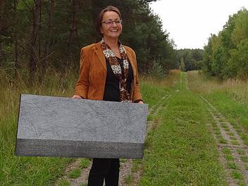 Andrea Thema mit einem ihrer Grenz-Kunstwerke auf dem Kolonnenweg des früheren Grenzstreifens. Foto: Johanna Eckert