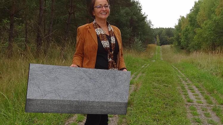 Andrea Thema mit einem ihrer Grenz-Kunstwerke auf dem Kolonnenweg des früheren Grenzstreifens. Foto: Johanna Eckert