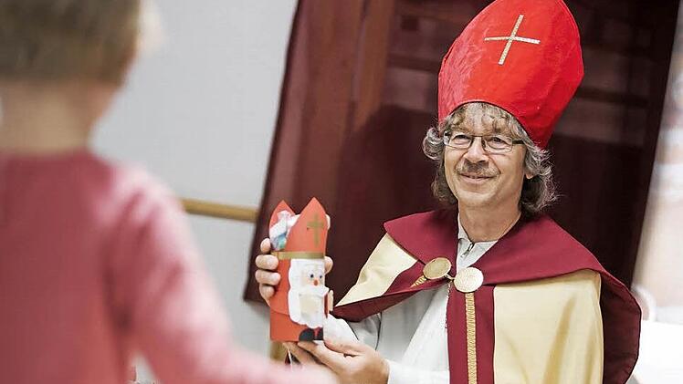 Der große Nikolaus, Jürgen Fischer, verschenkt Miniaturen, die mit kleinen Gaben gefüllt sind, an die Johannisthaler Kinder.  Fotos: Hendrik Steffens