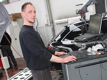 Patrick Hümmer ist einer der Lichtenfelser VAG-Mitarbeiter, die mit dem Diagnose-Testgerät die neue Software aufspielen. Foto: Matthias Einwag