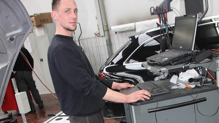 Patrick Hümmer ist einer der Lichtenfelser VAG-Mitarbeiter, die mit dem Diagnose-Testgerät die neue Software aufspielen. Foto: Matthias Einwag