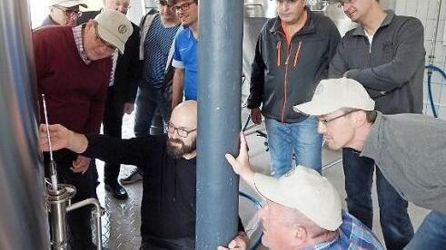 Braumeister Bernd Weibbrecht (knieend) erklärt den Bierpraktikanten das Würzespindeln.  Foto: Horst Wunner