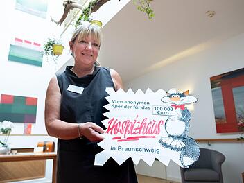 Die Hospizleiterin Petra Gottsand hält die "Wundertüte" in der die Spende übergeben wurde  in den Händen. Ein anonymer Wohltäter hat in Braunschweig 100 000 Euro an ein Hospiz gespendet. Foto: Peter Steffen/dpa