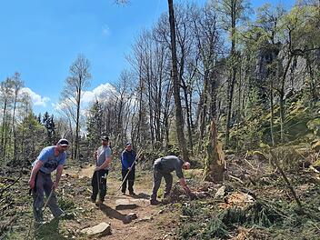 Die Gruppe von Kai-Uwe Rippstein (rechts) hat den Wanderweg entlang der Felswand nach den Baumfällarbeiten freigeräumt.