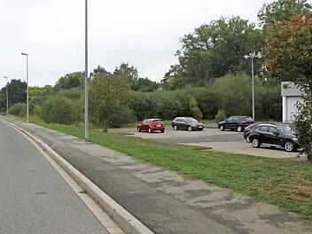 Auf einem Grundstück in der Lichtenfelser Mainau, unweit der Niederlassungen der Firmen Vögele (rechts) und Obi (links), möchte Martin Schramm die Asylbewerber-Unterkunft bauen. Foto: Matthias Einwag