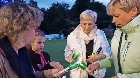 Die Gläubigen geben vor der Prozession um die Kirche am Vorabend des Mariä-Himmelfahrts-Tages das Licht von Kerze zu Kerze weiter.