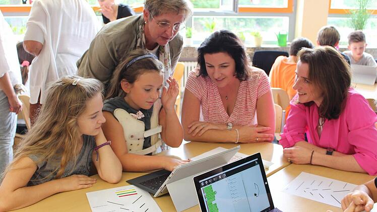 Tanja Böhm von Microsoft, Dorothee Bär und Schulleiterin Gisela Schott (von rechts) lassen sich das Programmieren erklären.  Fotos: Lisa Kieslinger