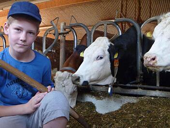 Simon schaufelt einen Haufen Silage zusammen, von dem die Kinder glauben, dass er für eine Kuh am Tag ausreicht. Er kommt dabei ganz schön ins Schwitzen. Fotos: Katharina Müller-Sanke