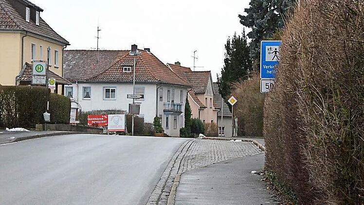 Das Schild, das 50 Meter vor dem Übergang auf den Verkehrshelfer hinweist, wird teilweise durch eine Hecke verdeckt. Fotos: Rainer Lutz