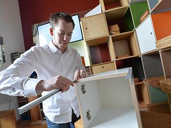 Jungmeister Valentin Schuhmann demonstriert, wie der Zusammenbau der Möbelfertigteile mit den selbst entwickelten Eckprofilen funktioniert. Fotos: Fee Hovehne