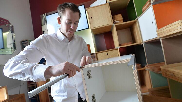 Jungmeister Valentin Schuhmann demonstriert, wie der Zusammenbau der Möbelfertigteile mit den selbst entwickelten Eckprofilen funktioniert. Fotos: Fee Hovehne