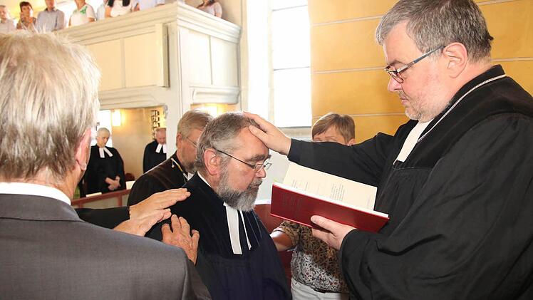 Mit Auflegen der Hände von Geistlichen und Kirchenvorstand wurde Pfarrer Leikert in sein Amt eingeführt. Foto: Michael Stelzner