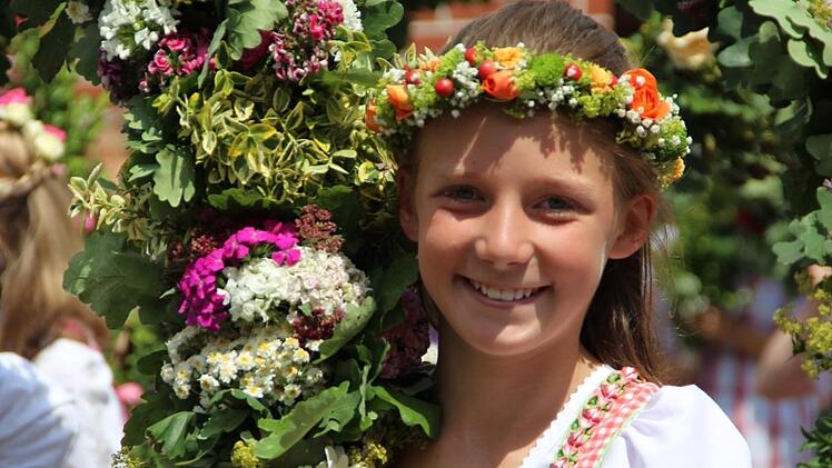 Hannah Roßmerkel und ihre Klassenkameraden aus der vierten Klasse tragen stolz ihre Blumenkränze durch Thurnau.Foto: Katharina Müller-Sanke