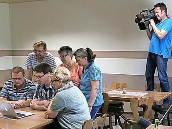 Das Fernsehteam drehte bei der Bürgerinitiative in Sand. Unser Bild zeigt sitzend am Tisch von links: Alfred Weiß, Mark Werner, Christine Rippstein. Stehend am Tisch von links: Rudolf Rippstein, Maria Rebhan, Karin Mühlfelder-Zinser. Kameramann Christian Wiens (rechts) nimmt die Szene auf.  Fotos: privat