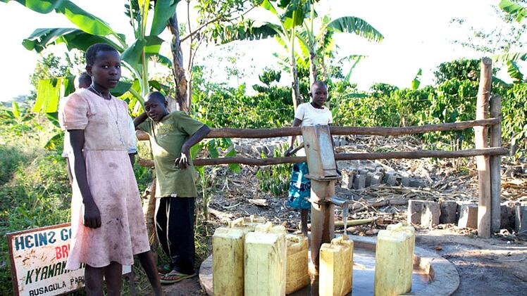 Kinder in Uganda müssen Wasser mit Kanistern aus weit entfernten Brunnen holen. Foto: Johanna Blum