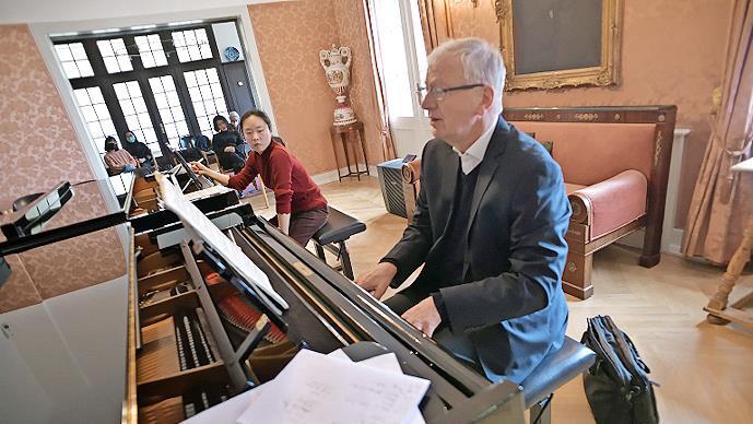 Arnulf von Arnim spielt mit seinem Meisterkurs in der Bibliothek von Haus Marteau.