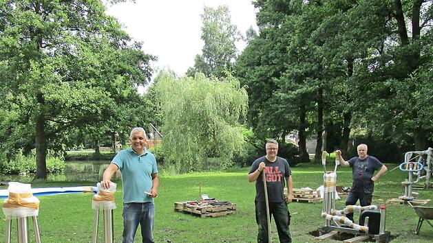 Noch sind die Outdoor-Fitnessger&auml;te teilweise verpackt, aber immerhin schon verankert. Gemeinderat Andree Barth (links) organisierte das Aufstellen der Ger&auml;te. Mit im Bild B&uuml;rgermeister Marc Benker und Gemeinderat Ulrich Reinhardt