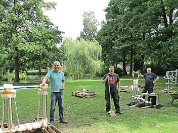 Noch sind die Outdoor-Fitnessgeräte teilweise verpackt, aber immerhin schon verankert. Gemeinderat Andree Barth (links) organisierte das Aufstellen der Geräte. Mit im Bild Bürgermeister Marc Benker und Gemeinderat Ulrich Reinhardt