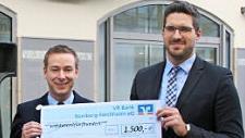 Christoph R&uuml;ger (rechts), stellvertretender Filialleiter der Volksbank-Hauptstelle, &uuml;bergab an Josua Flierl einen Scheck. Foto: pr