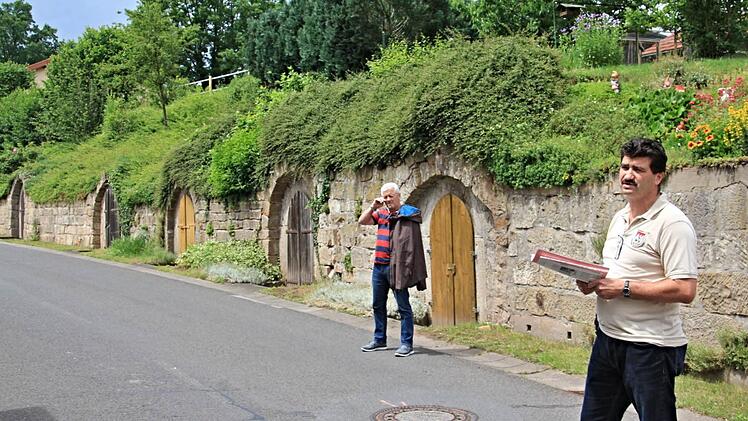 Uwe Rädlein (rechts) an der neu sanierten Mauer am Ortsausgang von Ibind in Richtung Hofheim. Foto: Helmut Will