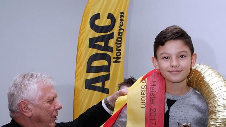 Der Sportleiter des ADAC Nordbayern, Alfred Thomaka, übergibt den Siegerkranz an Meister Julian Friemelt.Karlheinz Franz