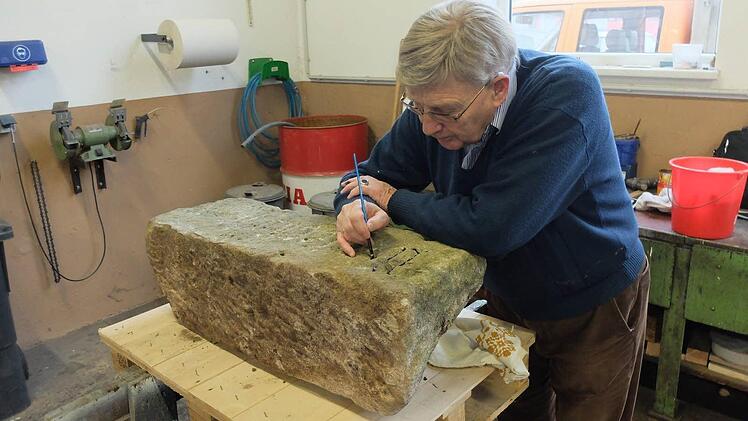 Mit aller Vorsicht hat Kreisheimatpfleger Günter Lipp die Inschrift des restaurierten Hochwassersteins nachgezogen.