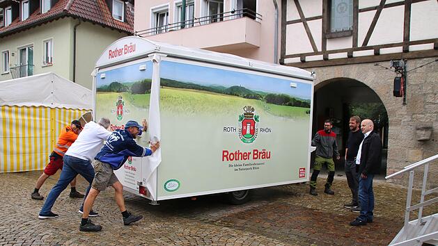 Mit vereinten Kr&auml;ften bringen TSV-Mitglieder und Wulf D&uuml;nisch (links) einen Getr&auml;nkewagen in Position. B&uuml;rgermeister Michael Kastl (rechts) und Kilian D&uuml;ring vom Stadtmarketing (daneben) freuen sich auf "Musik und M&auml;rkte". W&auml;hrend hier am Anger al...
