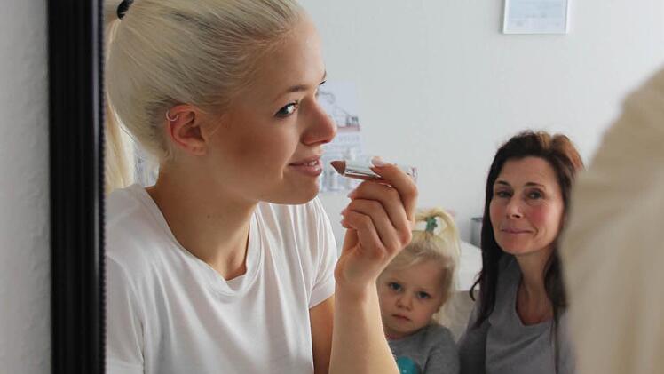 Michelle wird von ihrer kleinen Schwester Lia und Mutter Daniela beobachtet.