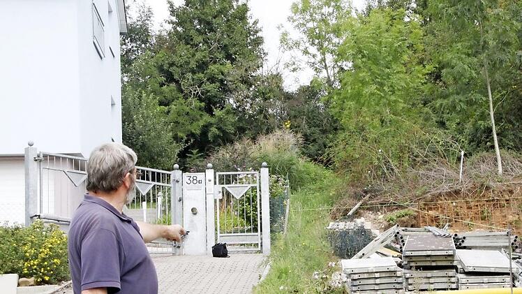 Wolfgang Spörlein fordert, dass der zugewucherte Pfad zwischen diesen beiden Grundstücken in der Rotbrunnenstraße in Richtung Ruhstraße wieder in einen begehbaren Zustand versetzt wird.  Foto: Andreas Oswald