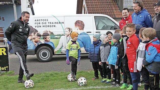 Die beiden DFB-Mobil-Teamer Mayed Dallos (links vorne) und Markus Büttner (links hinten) halten in Trailsdorf eine Demo-Trainingseinheit für die Kinder und deren Trainer.
