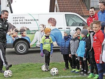 Die beiden DFB-Mobil-Teamer Mayed Dallos (links vorne) und Markus Büttner (links hinten) halten in Trailsdorf eine Demo-Trainingseinheit für die Kinder und deren Trainer.