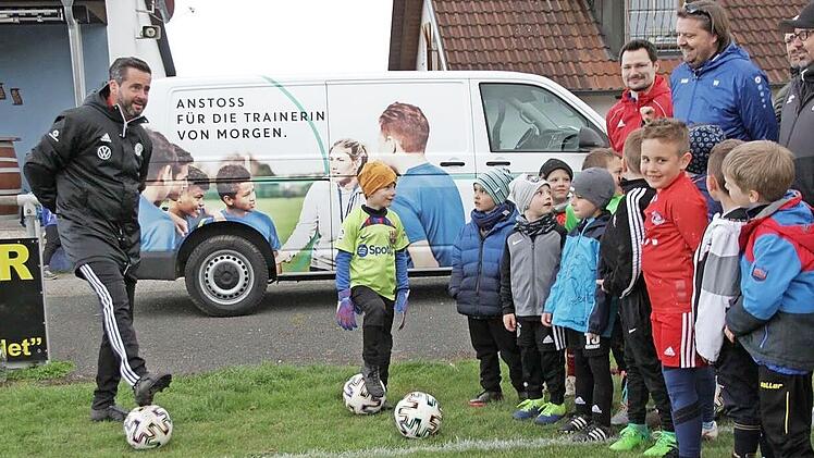 Die beiden DFB-Mobil-Teamer Mayed Dallos (links vorne) und Markus Büttner (links hinten) halten in Trailsdorf eine Demo-Trainingseinheit für die Kinder und deren Trainer.