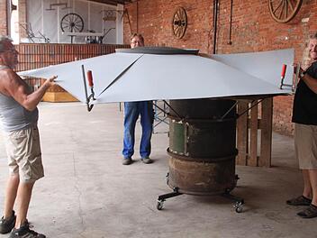 Sie packen mit an: Fritz Zeiger (von links), Bert Behling und Bürgermeister Wilhelm Friedrich heben das Dach des Ofens an. Foto: Sebastian Vogt