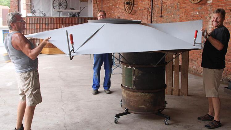 Sie packen mit an: Fritz Zeiger (von links), Bert Behling und Bürgermeister Wilhelm Friedrich heben das Dach des Ofens an. Foto: Sebastian Vogt