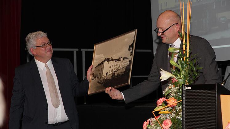 Der Eggolsheimer Bürgermeister Claus Schwarzmann übergab als Präsent der Gemeinde ein Bild aus den 50er Jahren des Lindner-Gebäudes, in dem die Schule jetzt beheimatet ist. Foto: Mathias Erlwein