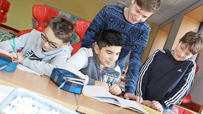 Louis Witzgall, Ahmet Avara und Julius Bülling (von links) sind froh, dass Lerntutor Nick Baier (hinten) ihnen im Fach Deutsch Nachhilfe gibt.  Foto: Lisa Kieslinger
