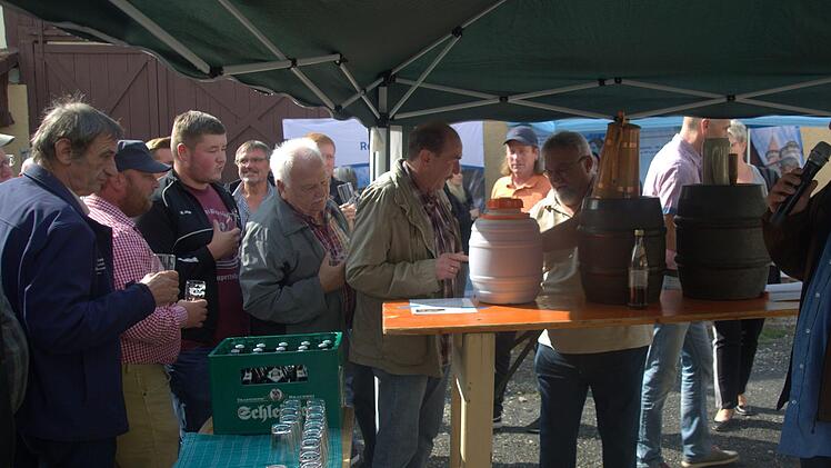 Auf reges Interesse stieß die Verkostung von fünf Bieren aus dem Rodachtal, die Biersommelier Markus Raupach (vorn) auf Einladung der Initiative Rodachtal am Samstag beim Brauhausfest in Unterelldorf anbot. Während Raupach die einzelnen Sorten erläuterte, standen die Test-Trinker geduldig Schlange, um sich - wie hier von Helfried Schleicher (Brautraditionsverein Unterelldorf) - einschenken zu lassen. Foto: Bettina Knauth