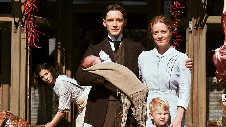 Fidelis Waldvogel (Jonas Nay) und seine Frau Eva (Leonie Benesch, rechts) lassen sich mit ihrem Nachwuchs ablichten. Mit Delphine (Aylin Tezel) arbeitet eine weitere Deutsche in der Wildwest-Metzgerei der ausgewanderten Schwaben.